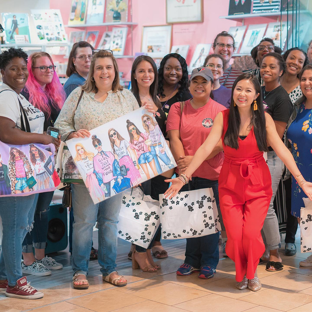 Group of smiling women holding art.