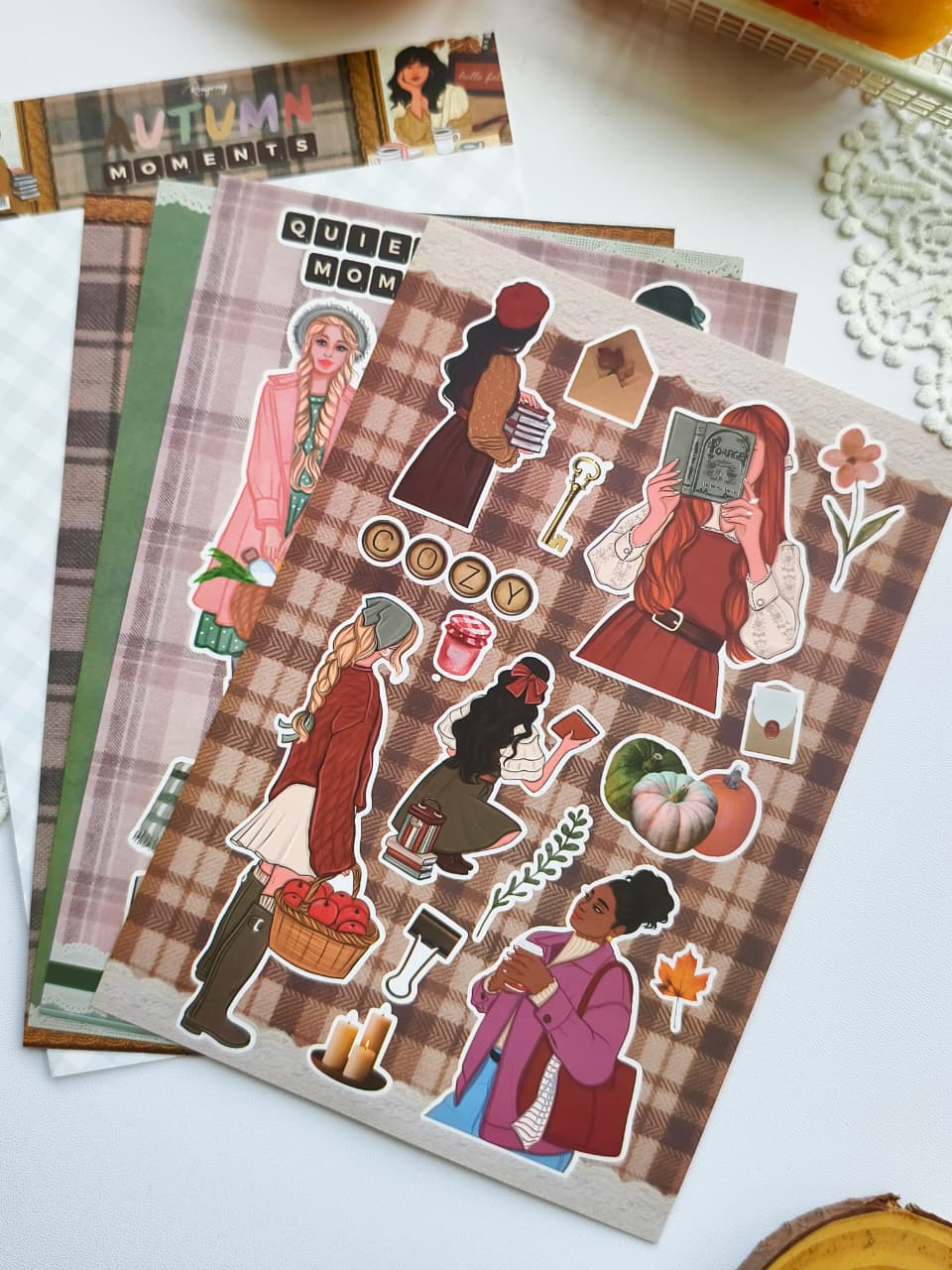 Autumn Moments vinyl sticker sheet with cozy reading girls, pumpkins, books, candles, flowers, apple picking, and warm fall-inspired decorative stickers.