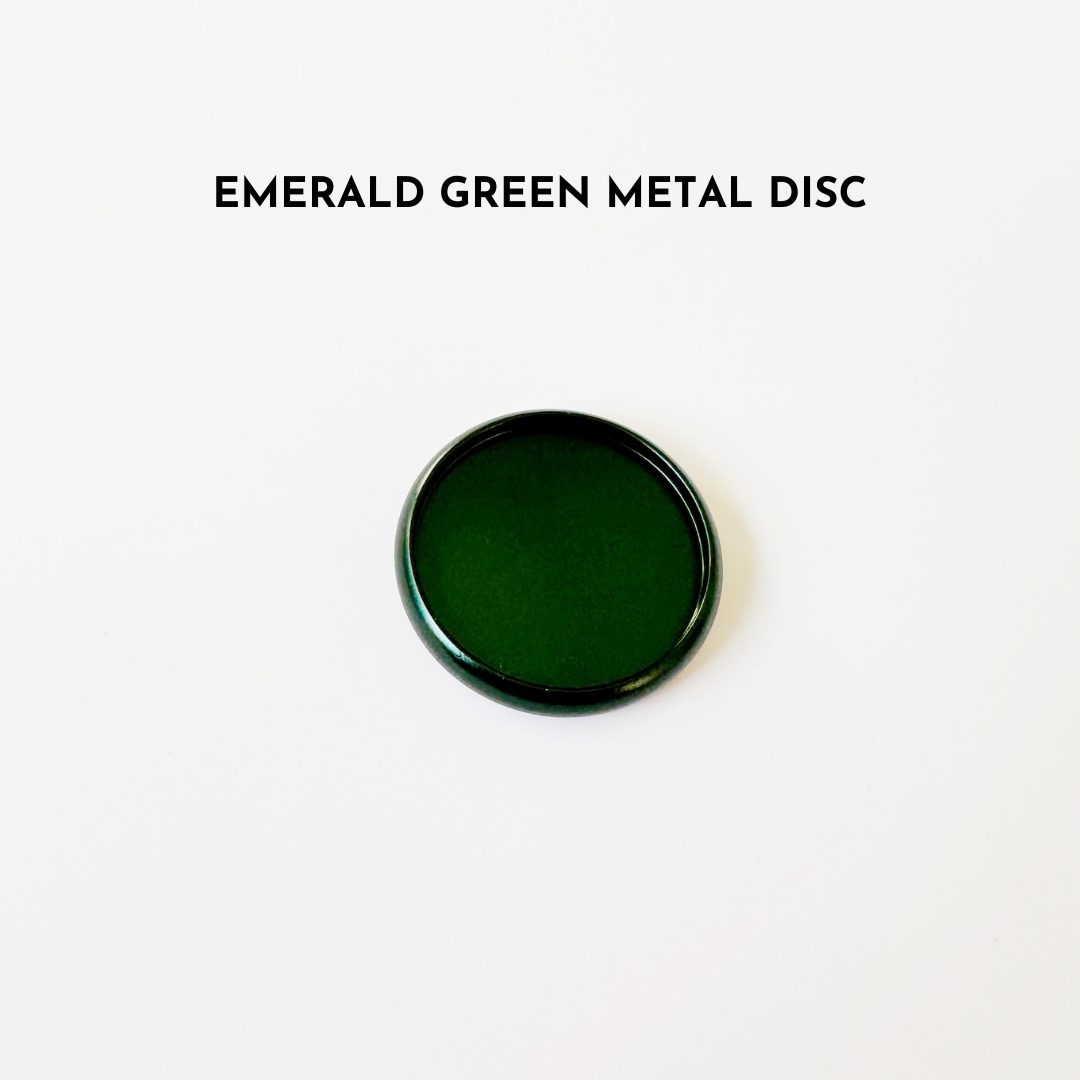Emerald green metal disc on white background
