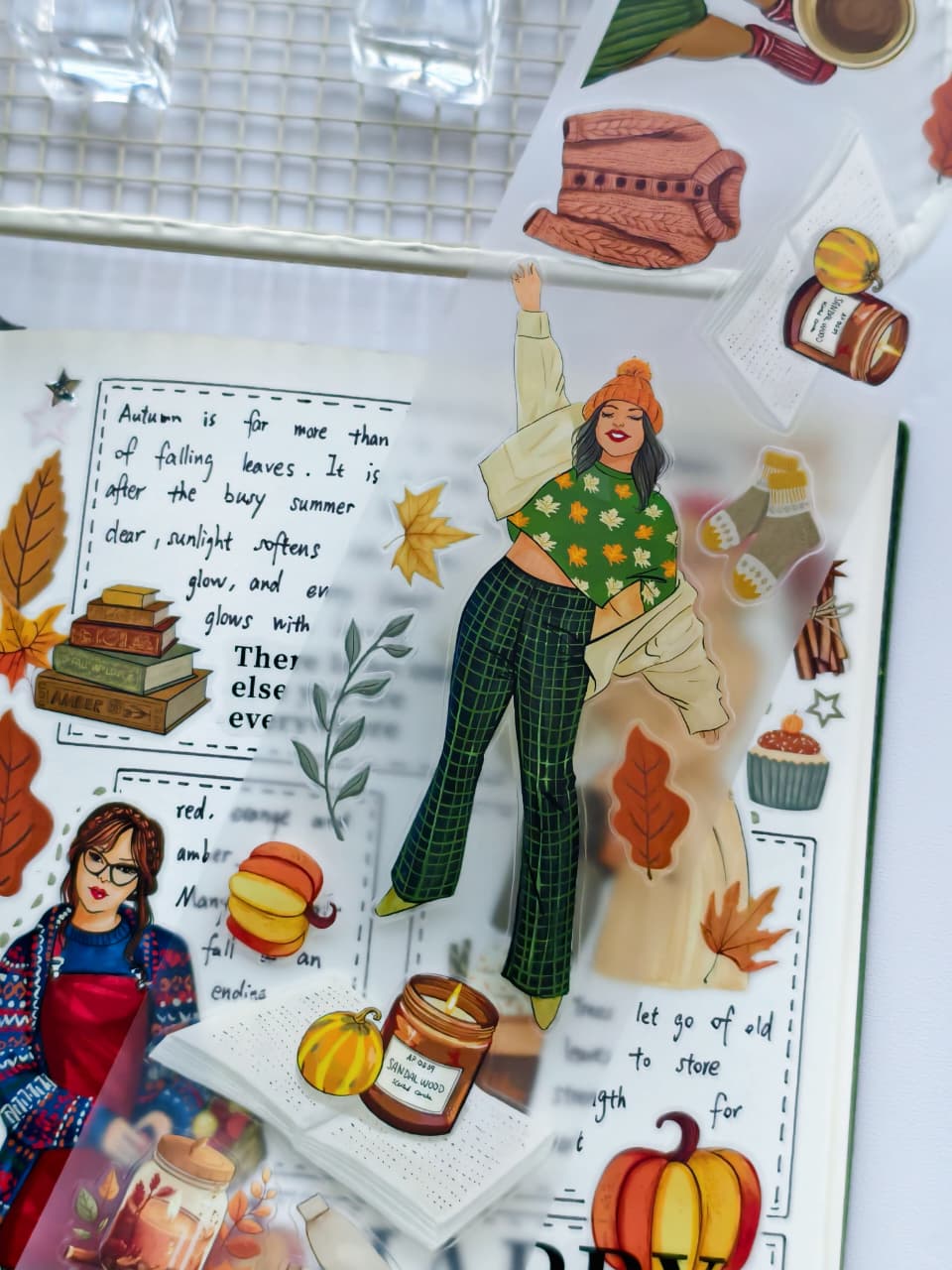 Amber Allure pre-cut PET tape featuring fashionable autumn girl stickers, pumpkins, candles, books, sweaters, leaves, and cozy seasonal decorative elements on transparent PET material.