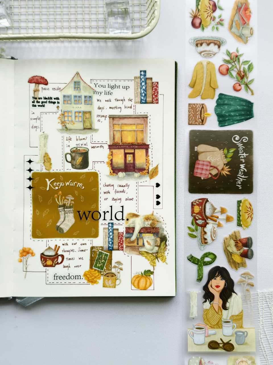 Autumn-inspired journal layout showcasing pre-cut PET stickers of coffee cups, cozy sweaters, pumpkins, fall cafés, books, and seasonal accents arranged around handwritten journaling.