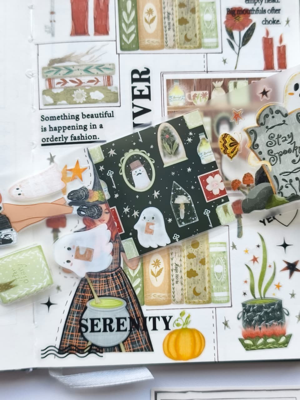 Close-up of transparent PET stickers featuring friendly ghosts, potion bottles, magical books, pumpkins, mushrooms, autumn leaves, and whimsical witch-themed illustrations from the Boo&