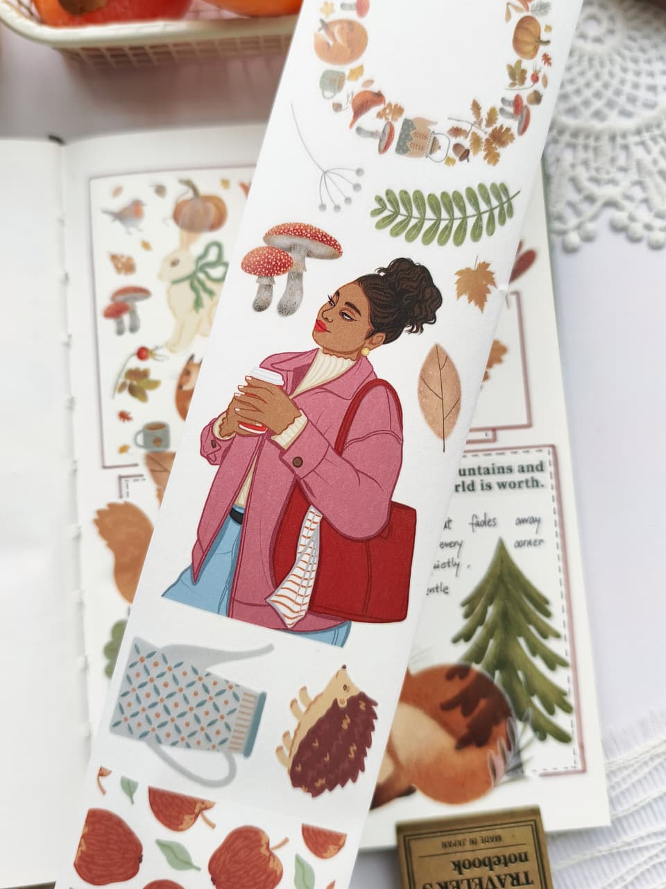 Close-up of Foxberry Tales Washi Tape featuring a cozy autumn girl in a pink jacket holding a hot drink, surrounded by mushrooms, leaves, woodland accents, and soft fall-inspired illustrations.