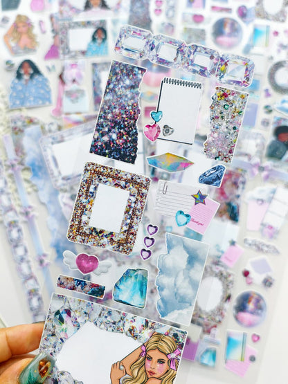 Close-up of transparent crystal-themed stickers featuring glitter textures, gem frames, sparkly hearts, clouds, holographic diamonds, and decorative journaling pieces.