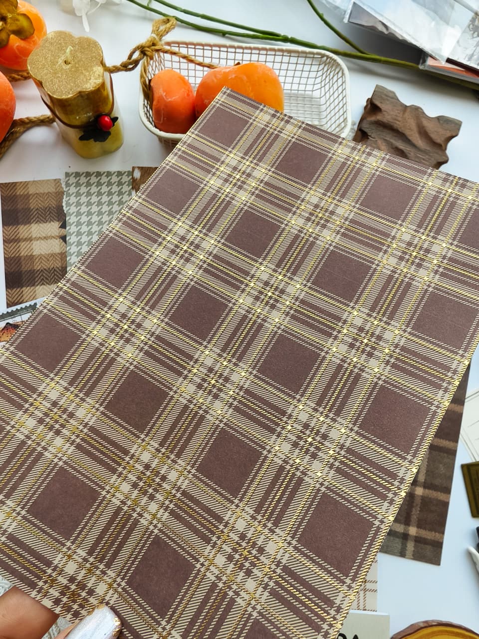 Hand holding a brown plaid scrapbooking paper with elegant gold foil detailing from the Dear Autumn collection, perfect for cozy fall journals, planners, scrapbooks, and paper crafts.