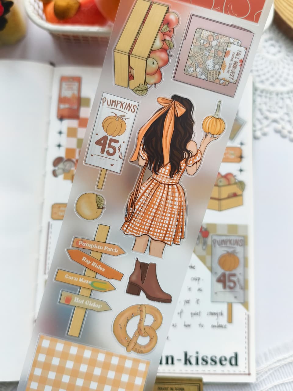 Close-up of Fall Festival PET Tape showcasing pumpkin patch signs, apple crates, pumpkins, autumn girl illustrations, boots, pretzels, harvest tickets, and cozy seasonal accents on transparent PET material.