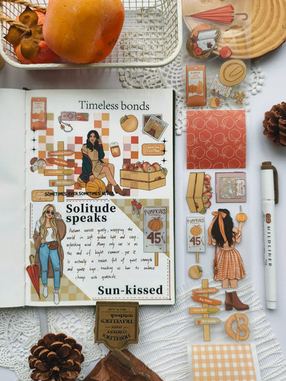 Open journal featuring a cozy autumn scrapbook spread decorated with Fall Festival PET Tape. The layout includes pumpkin patch illustrations, autumn girls, apples, warm drinks, and soft gingham accents in warm fall tones.