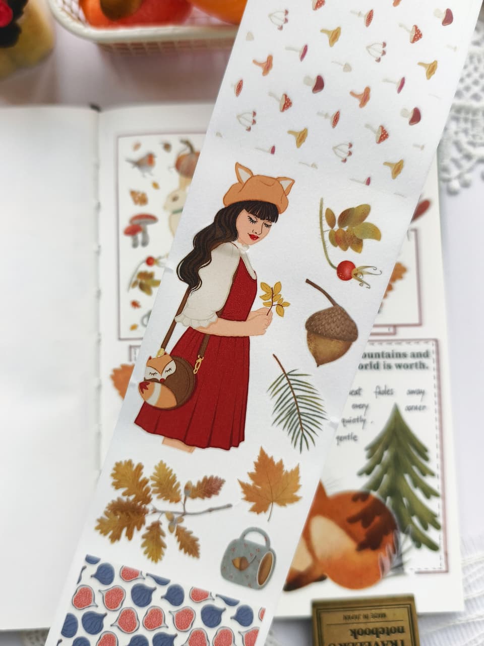 Close-up of Foxberry Tales Washi Tape showcasing woodland animals, mushrooms, foxes, pears, pumpkins, birds, cozy mugs, autumn leaves, acorns, and a charming autumn girl in soft watercolor style.