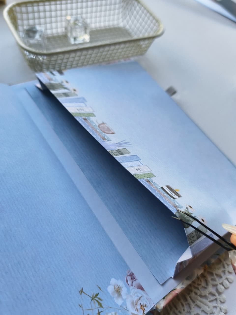 A close-up of the Gentle Focus journal opened to reveal its thick, high-quality pages and beautifully printed floral inner cover. The page edges feature a charming bookshelf design, highlighting the journal&