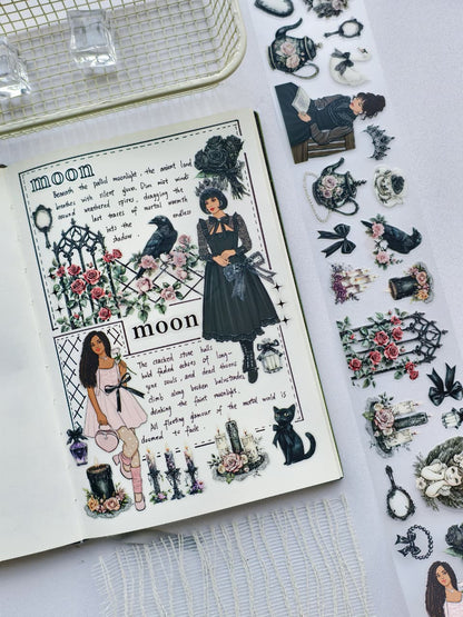 Journal spread decorated with Gothic Coquette pre-cut PET tape featuring gothic girls, ravens, roses, black cats, candles, ornate gates, and romantic vintage elements.