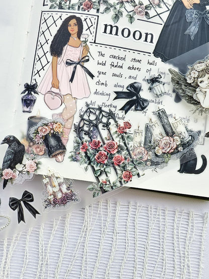 Close-up of Gothic Coquette pre-cut PET tape featuring gothic floral gates, black bows, candles, ravens, roses, angels, and elegant fashion girl stickers on transparent PET material.