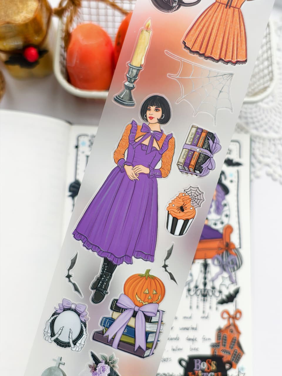 Close-up of Happy Haunts PET Tape highlighting elegant Halloween illustrations including a woman in a purple dress, stacked books, candle, spiderweb, cupcake, bats, pumpkins, and vintage gothic accents.