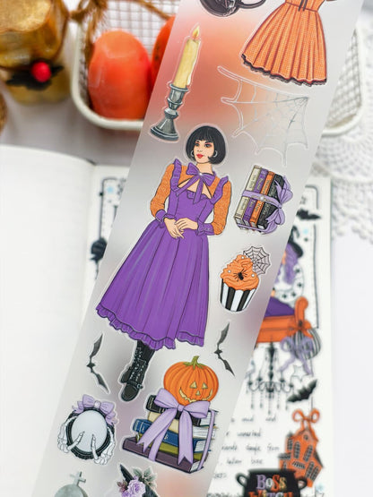 Close-up of Happy Haunts PET Tape highlighting elegant Halloween illustrations including a woman in a purple dress, stacked books, candle, spiderweb, cupcake, bats, pumpkins, and vintage gothic accents.