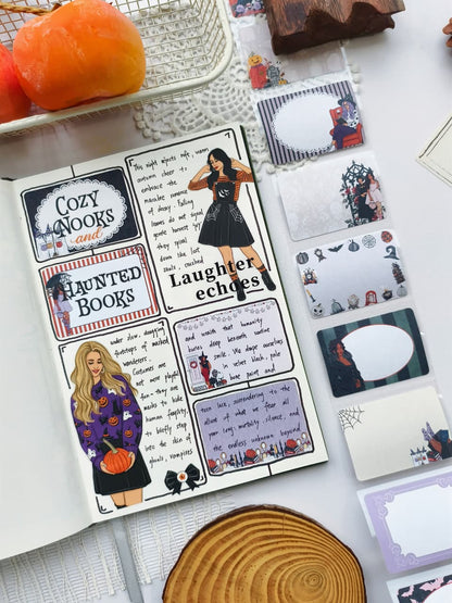 Angled view of a Halloween journal layout decorated with spooky sticker art, accompanied by Wicked Little Notes sticky notes featuring elegant frames, witches, gothic characters, and blank spaces for notes.