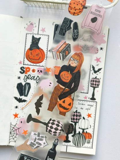 Close-up of transparent pre-cut PET stickers featuring a stylish girl with a pumpkin purse, spooky books, bats, pumpkins, spider webs, and playful Halloween decorations from the Hey Boo collection.