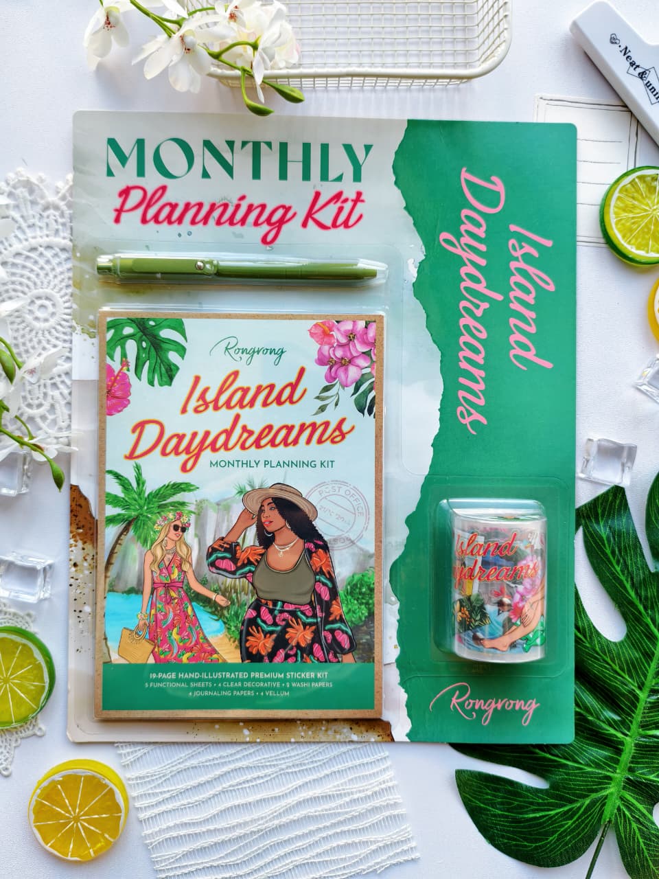 Complete Island Daydreams Monthly Planning Kit Bundle featuring a premium sticker book, tropical-themed washi tape, green pen, and island-inspired planner accessories with vibrant floral and beach vacation artwork.