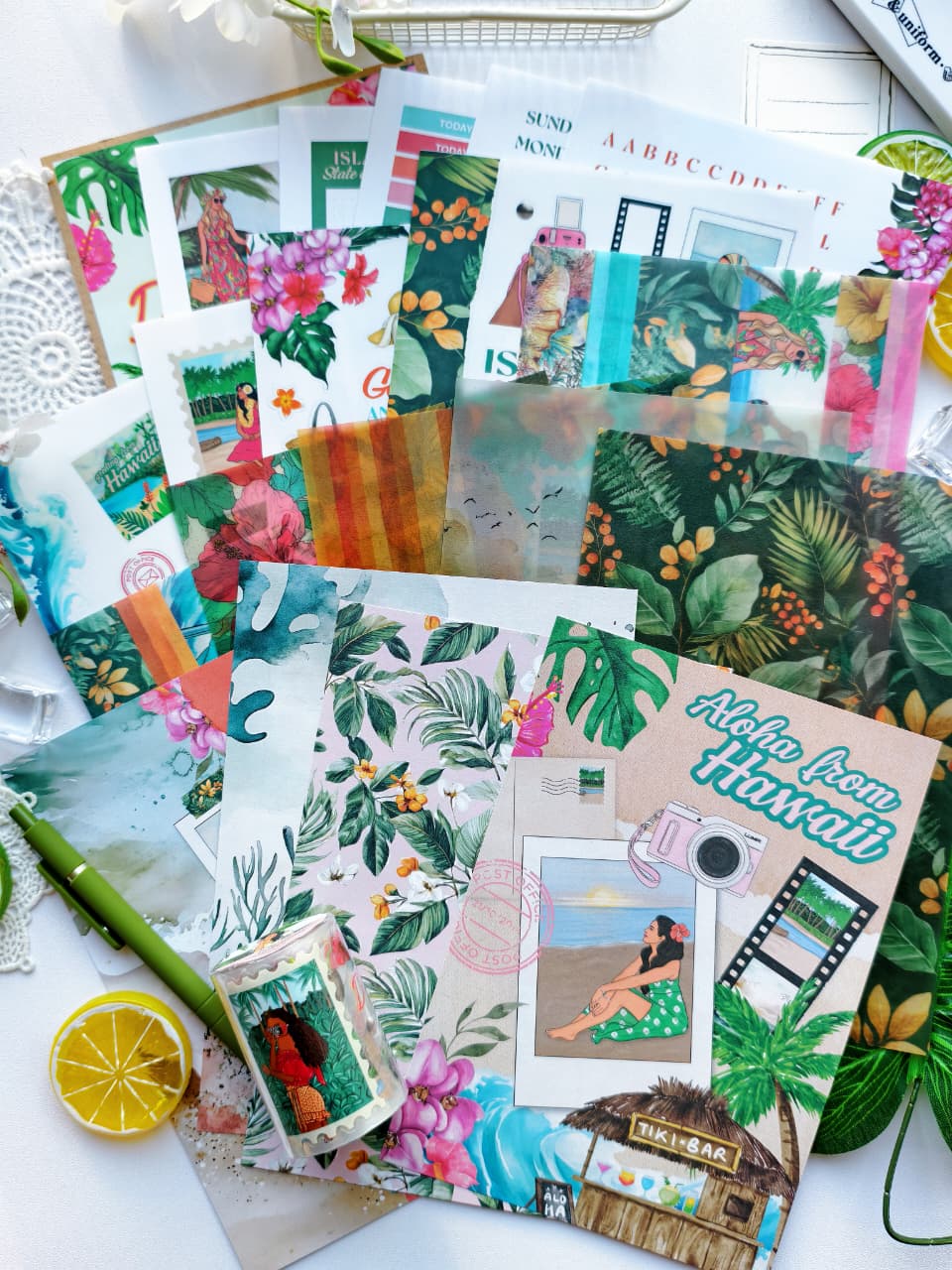 Flat lay of the Island Daydreams Monthly Planning Kit accessories featuring decorative papers, vellum, tropical journaling cards, island-inspired stickers, floral ephemera, and Hawaiian-themed stationery supplies.