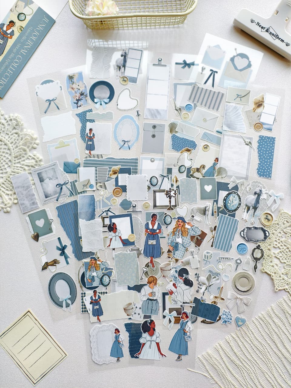 Collection of decorative paper cutouts on a light surface with a basket and books in the background.