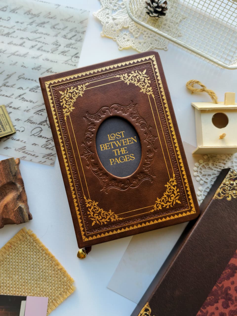 A brown leather-bound book with ornate gold detailing and the title &