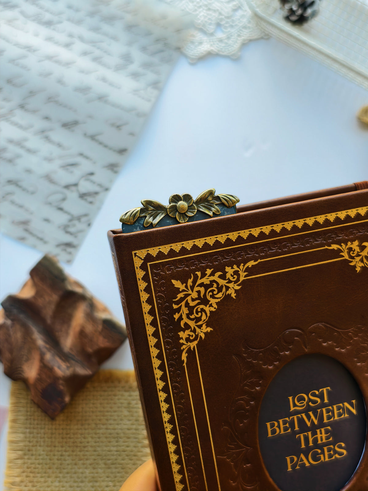 A close-up of a brown leather-bound book with gold ornamental border detailing and a circular black label reading &