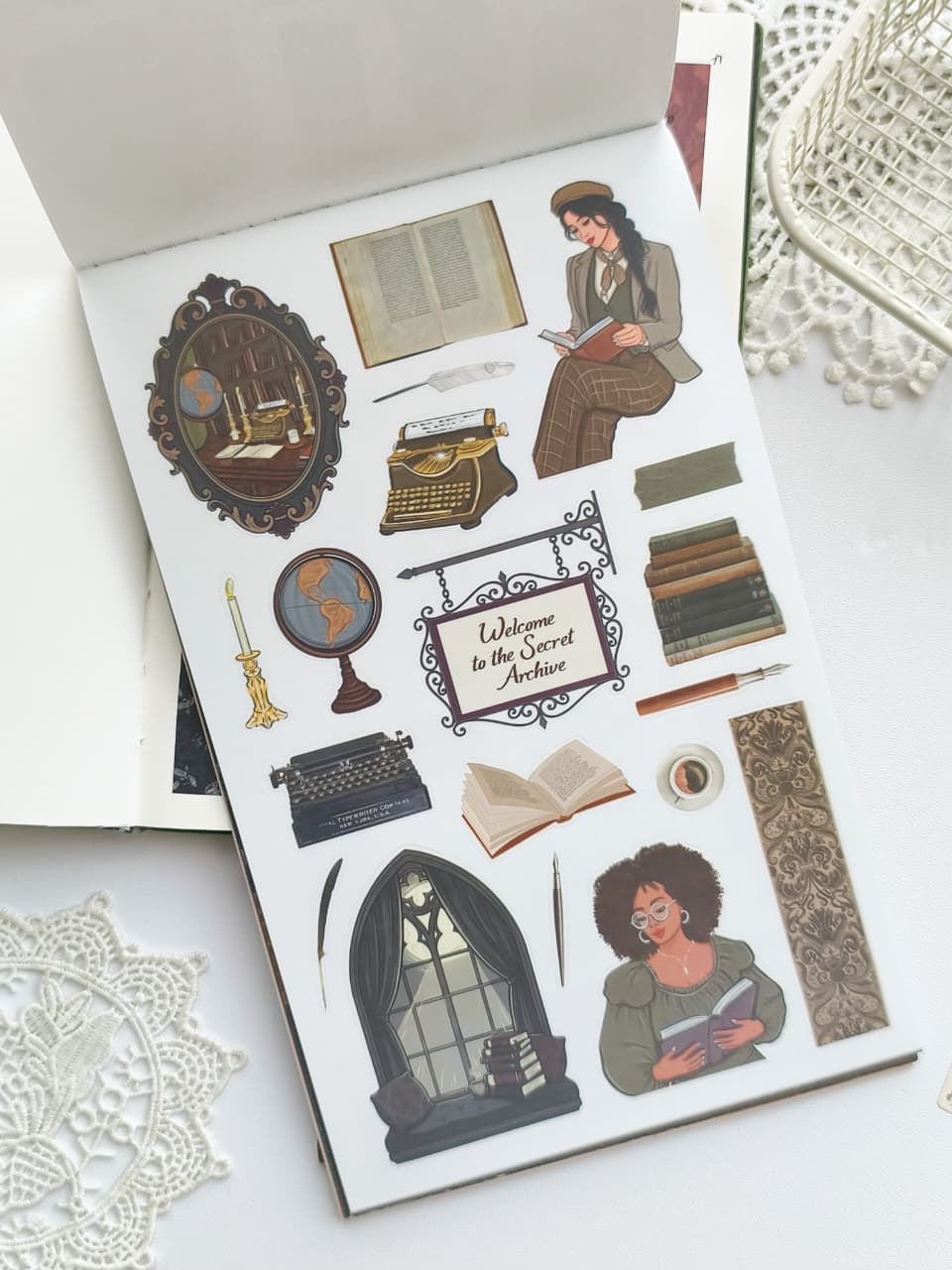 A sheet of vintage-style illustrated stickers displayed on a white surface, featuring a librarian reading, a typewriter, books, a globe, a candle, a framed sign reading 'Welcome to the Secret Archive,' and other cozy reading-themed motifs.