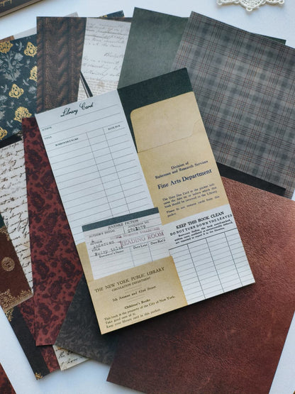 A flat-lay arrangement of vintage-style paper sheets and cardstock pieces in assorted patterns and colors, including plaid, damask, script, and cream tones, with one card reading &