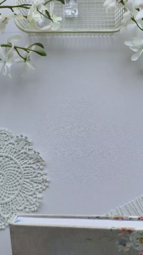 A flip-through video of the Gentle Focus journal showcasing its elegant floral hardcover, premium paper, and thoughtfully designed interior pages, including monthly planning, weekly layouts, and note sections. The journal is displayed on a soft white background with delicate floral accents, highlighting its calming, feminine aesthetic.