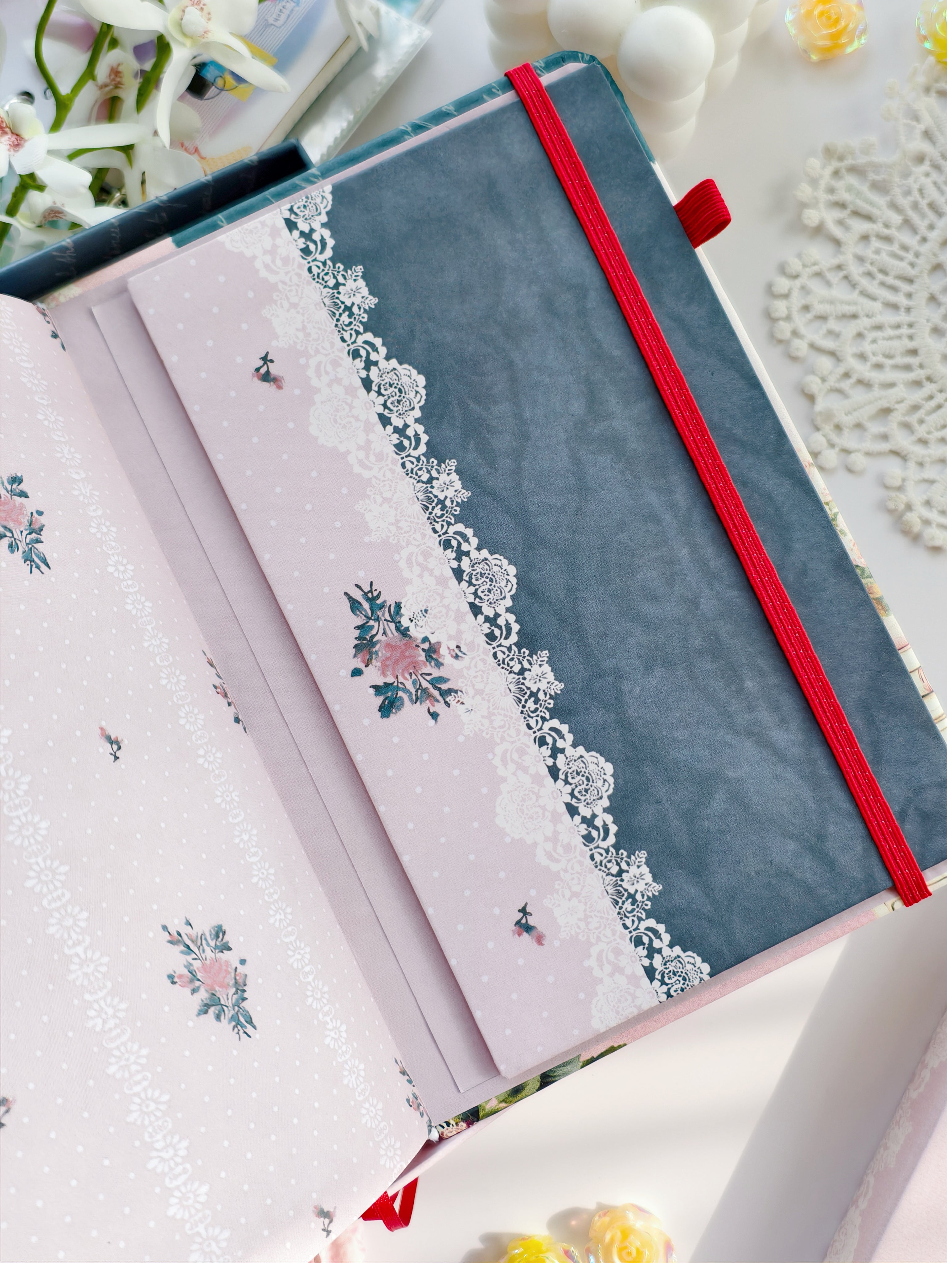 Close-up of floral envelope insert with lace design inside romantic reading journal