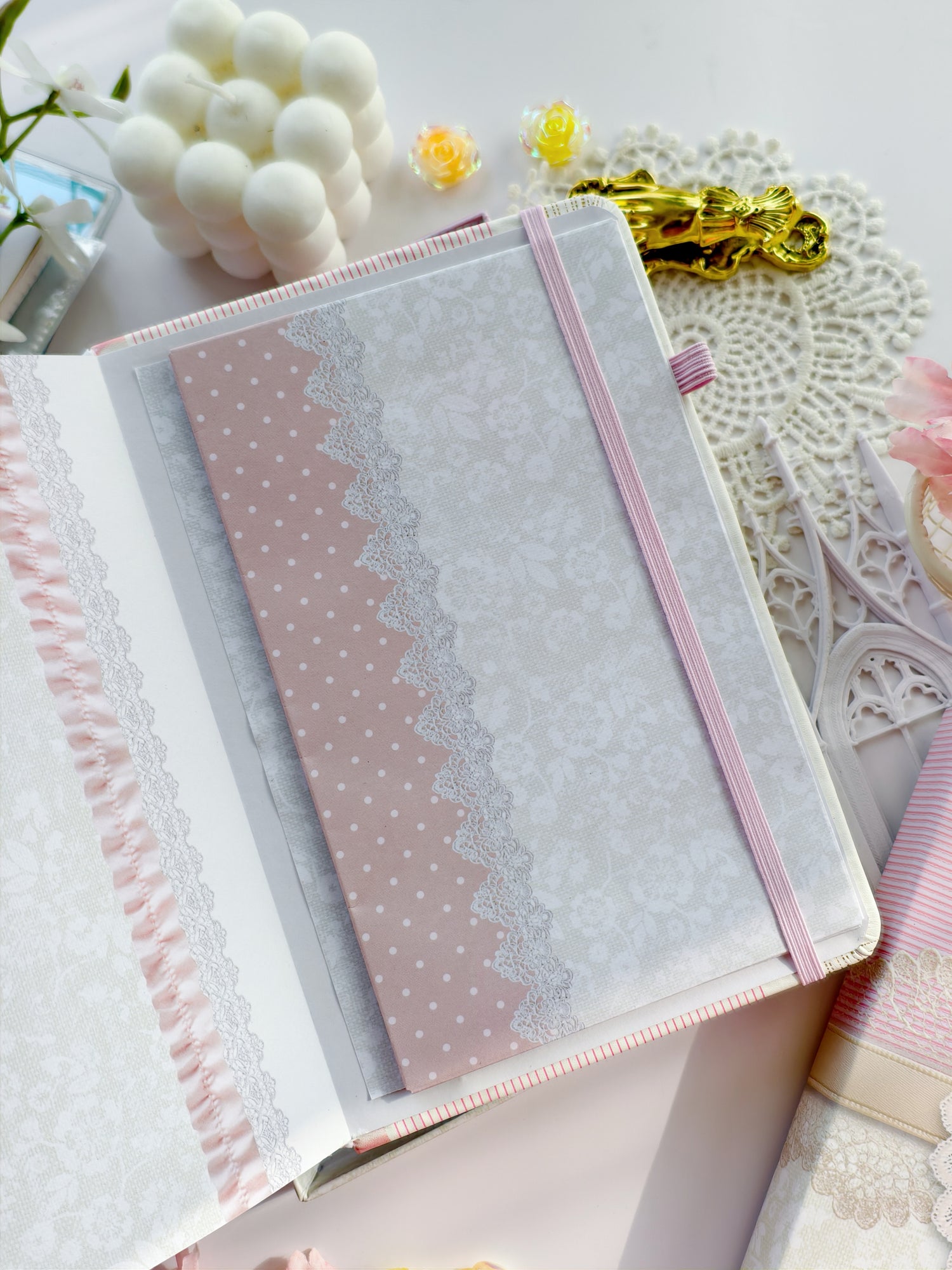 Soft Girl Era journal with pink elastic band and delicate lace cover design styled in a feminine flatlay