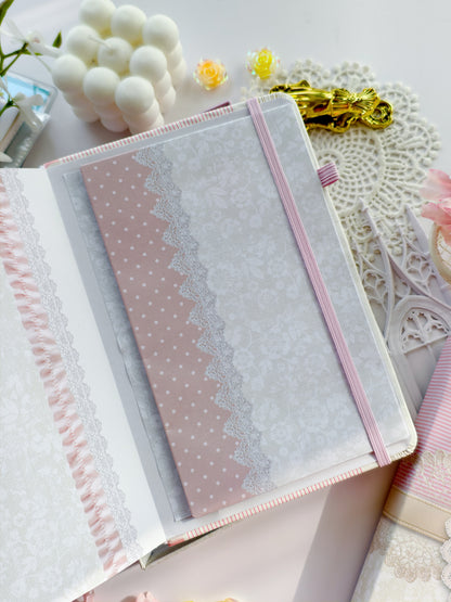 Soft Girl Era journal with pink elastic band and delicate lace cover design styled in a feminine flatlay